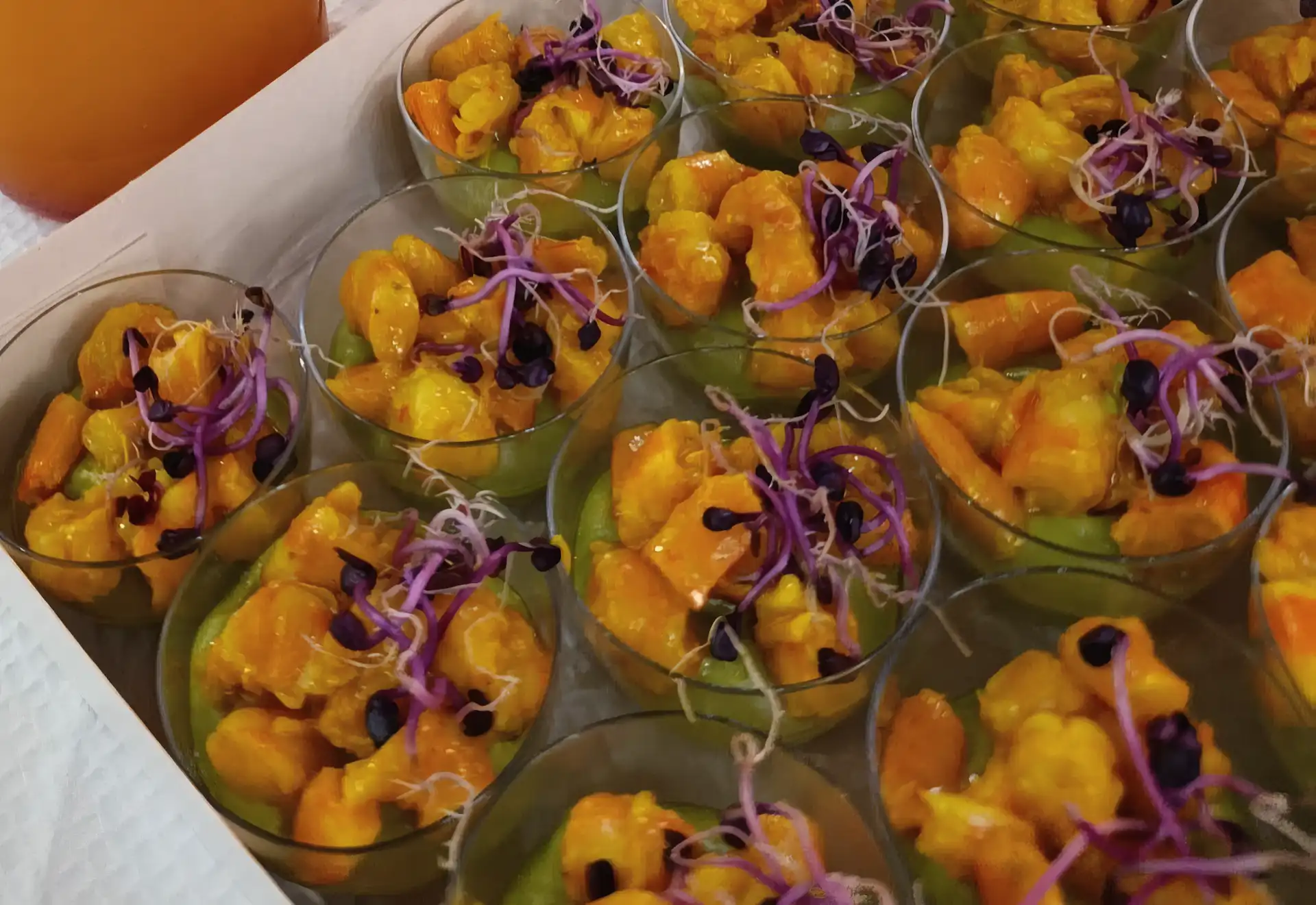 Assortiment de petites quiches dorées et wraps roulés jaunes sur plateau noir.